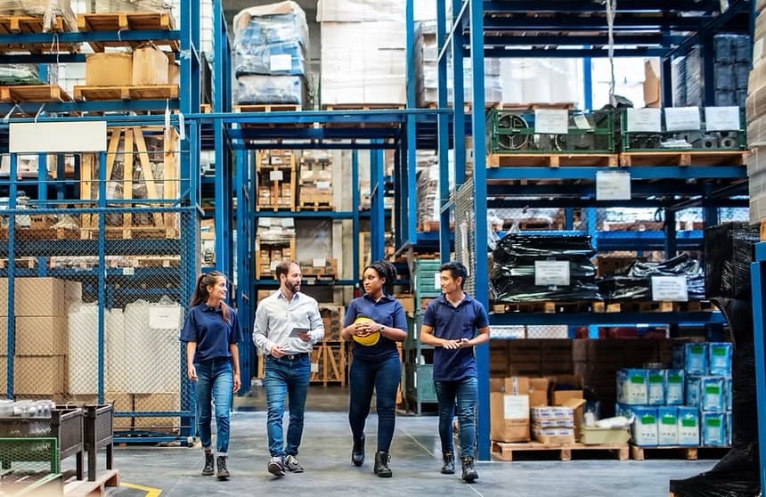 Une équipe dans un entrepôt logistique, entourée de palettes de produits